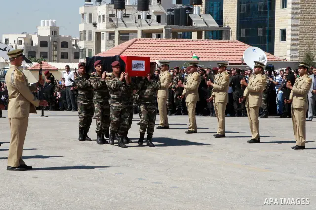 Members of the Palestinian security forces carry flag-covered coffins containing the remains of Palestinian militants during an official ceremony in the West Bank city of Ramallah May 31, 2012. The remains of 91 Palestin...