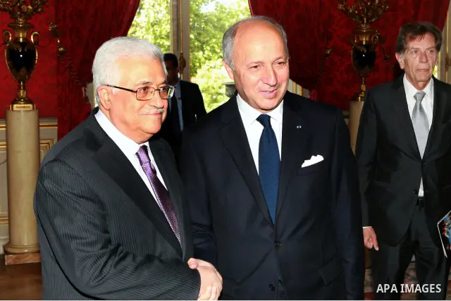 Palestinian President Mahmoud Abbas greets French Foreign Affairs Minister Laurent Fabius prior to their meeting at the Quai d'Orsay in Paris. Photo by Thaer Ganaim