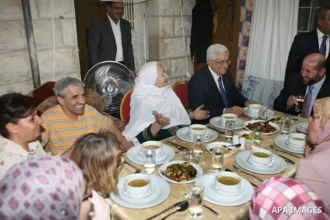 Palestinian President Mahmoud Abbas (Abu Mazen) breaks his fast with a Palestinian indigent family during the holy month of Ramadan, in the West Bank city of Ramallah on 06 August 2012. Photo by Thaer Ganaim