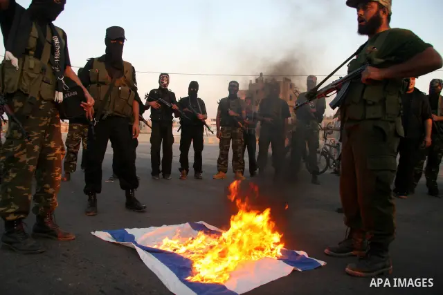 Palestinian militants of the military wing of the popular resistance committees "El-Nasser Salah El-Deen brigades" burn the Israeli Flag during a protest calling for lift the siege on Gaza, in Deer El-Balah town Central...