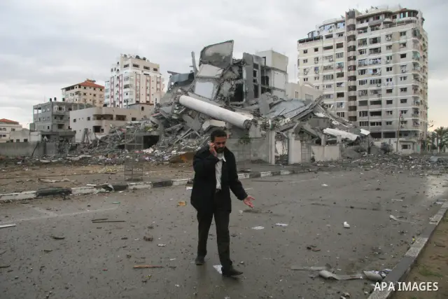 Palestinians run near a Hamas government building destroyed after an Israeli air strike in Gaza January 1, 2009. Israeli warplanes attacked government buildings in the Gaza Strip on New Year's Day after Israel and its Is...
