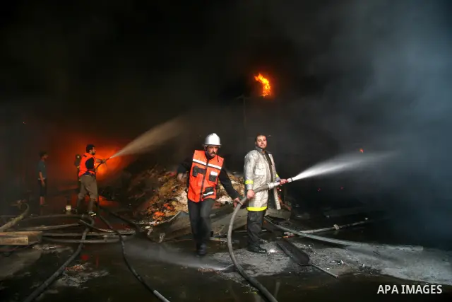 A Palestinian firefighter gestures as he and others try to put out a fire at the United Nations headquarters after it was hit in Israeli bombardment in Gaza City, Thursday, Jan. 15, 2009. Israel shelled the United Nation...