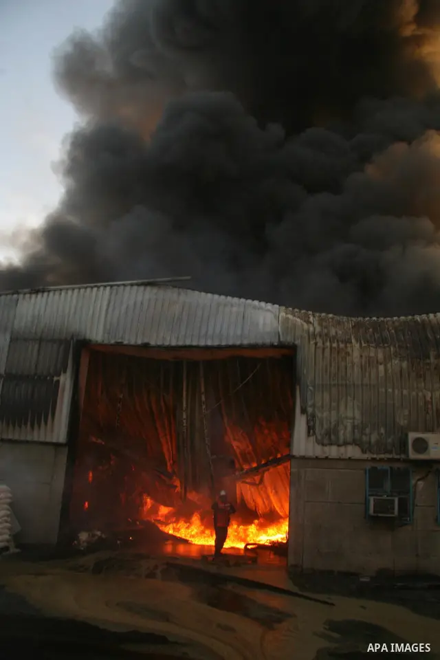 A Palestinian firefighter gestures as he and others try to put out a fire at the United Nations headquarters after it was hit in Israeli bombardment in Gaza City, Thursday, Jan. 15, 2009. Israel shelled the United Nation...