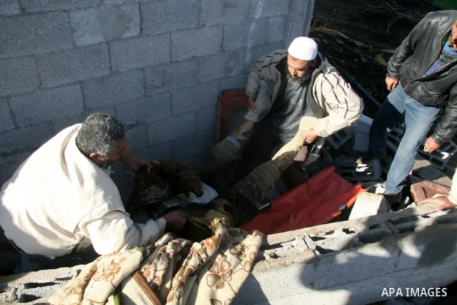 A body of a Palestinian man from the Samoni family, who was killed on Jan. 5 during an Israeli army operation in Gaza, is removed from the rubble of the family house in Gaza City, Sunday, Jan. 18, 2009. Israeli troops in...