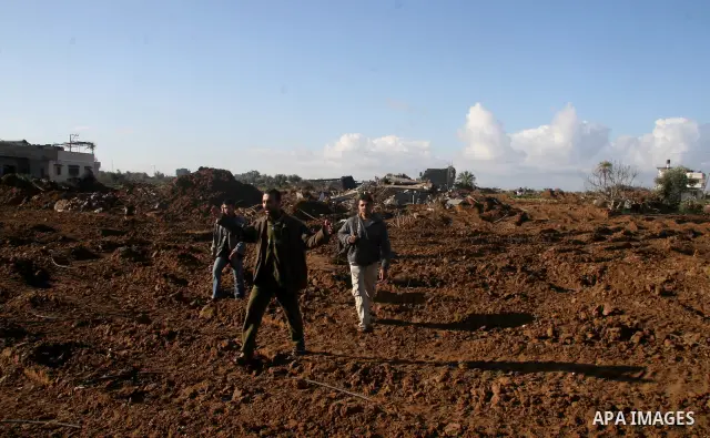 A Palestinian carries a destroyed house in the Zeitoun neighborhood in Gaza City, Sunday, Jan. 18, 2009. Gaza Strip militants offered Israel a weeklong truce beginning Sunday, but conditioned longer-term quiet on a compl...