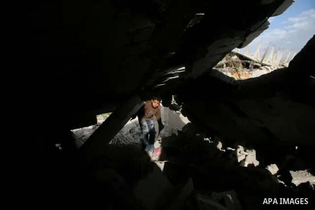 A Palestinian girl runs past destroyed buildings in the east Jabaliya neighbourhood, northern Gaza Strip, 26 January 2009. Hundreds of homes in this area were blown up or bulldozed by Israeli troops who wentered the area...