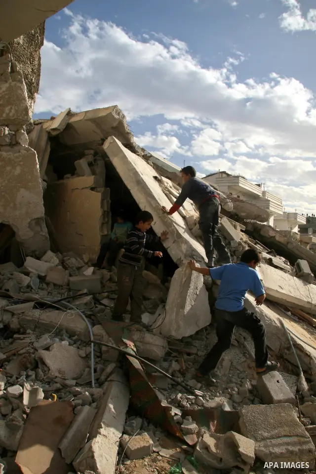 A Palestinian family sit next to their destroyed home in the area of east Jebaliya, in the northern Gaza Strip, Wednesday Jan. 28, 2009. The house was destroyed in the last Israeli military offensive. U.S. President Bara...