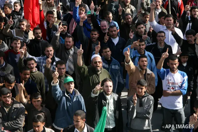 A Turkish flag is seen as Palestinians pray in front of the destroyed parliament building prior to attending a rally in support of Hamas in Gaza city, Friday Jan. 30, 2009. Turkish Prime Minister Tayyip Erdogan is winnin...