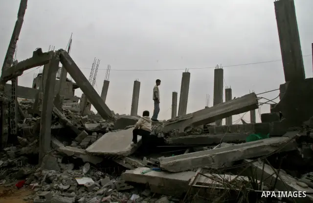 Palestinians sit in a makeshift shelter near their house destroyed during Israel's offensive, in Gaza City February 8, 2009. APAIMAGES PHOTO / Ashraf Amra
