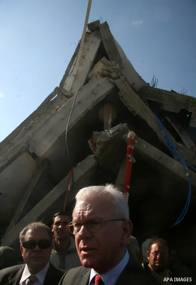 European Union (EU) Parliament President Hans-Gert Poettering (R) hold hands with a Palestinian man during a visit to a Jabalia district that was bombed during Israel's 22-day offensive on the Gaza Strip, on February 23,...