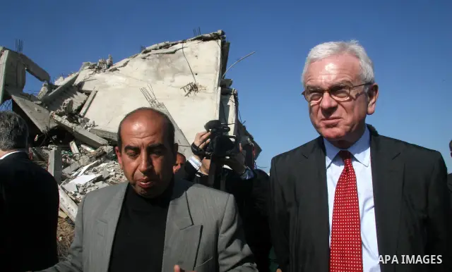 European Union (EU) Parliament President Hans-Gert Poettering (R) hold hands with a Palestinian man during a visit to a Jabalia district that was bombed during Israel's 22-day offensive on the Gaza Strip, on February 23,...