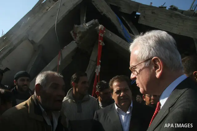 European Union (EU) Parliament President Hans-Gert Poettering (R) hold hands with a Palestinian man during a visit to a Jabalia district that was bombed during Israel's 22-day offensive on the Gaza Strip, on February 23,...