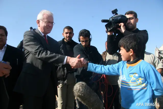 European Union (EU) Parliament President Hans-Gert Poettering (R) hold hands with a Palestinian man during a visit to a Jabalia district that was bombed during Israel's 22-day offensive on the Gaza Strip, on February 23,...