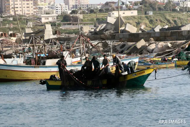 Palestinian fishermen collect their catch of fish off the coast of Gaza City on February 26, 2009. APAIMAGES PHOTO / Ashraf Amra