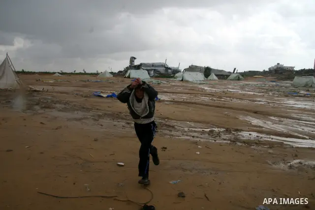 A Palestinian evacuates his belongings from a tent that housed people who had lost their homes during Israel's 22-day offensive, after heavy rain in east of Gaza March 1, 2009. The World Bank said on Sunday it would urge...