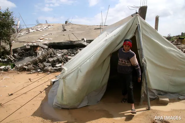A Palestinian evacuates his belongings from a tent that housed people who had lost their homes during Israel's 22-day offensive, after heavy rain in east of Gaza March 1, 2009. The World Bank said on Sunday it would urge...