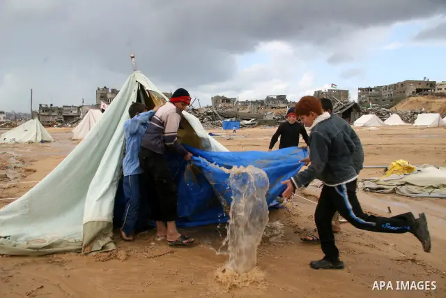 A Palestinian evacuates his belongings from a tent that housed people who had lost their homes during Israel's 22-day offensive, after heavy rain in east of Gaza March 1, 2009. The World Bank said on Sunday it would urge...