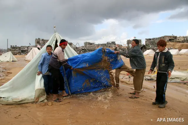 A Palestinian evacuates his belongings from a tent that housed people who had lost their homes during Israel's 22-day offensive, after heavy rain in east of Gaza March 1, 2009. The World Bank said on Sunday it would urge...