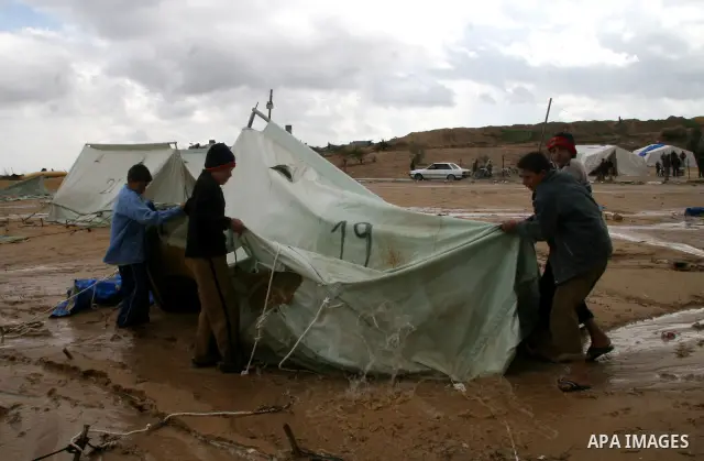 A Palestinian evacuates his belongings from a tent that housed people who had lost their homes during Israel's 22-day offensive, after heavy rain in east of Gaza March 1, 2009. The World Bank said on Sunday it would urge...