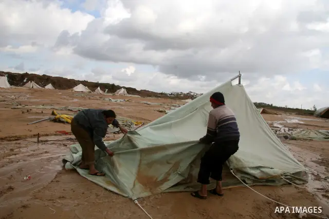 A Palestinian evacuates his belongings from a tent that housed people who had lost their homes during Israel's 22-day offensive, after heavy rain in east of Gaza March 1, 2009. The World Bank said on Sunday it would urge...