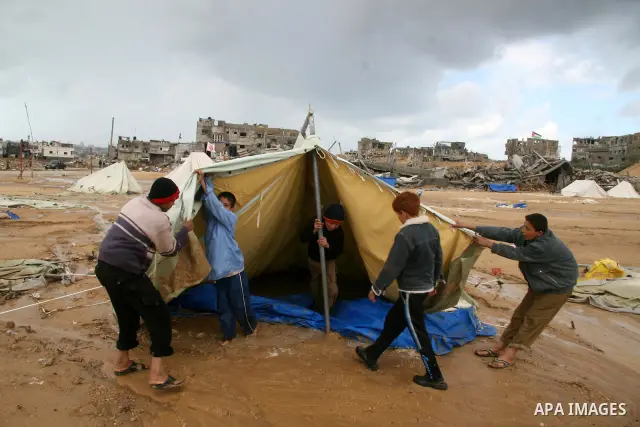 A Palestinian evacuates his belongings from a tent that housed people who had lost their homes during Israel's 22-day offensive, after heavy rain in east of Gaza March 1, 2009. The World Bank said on Sunday it would urge...