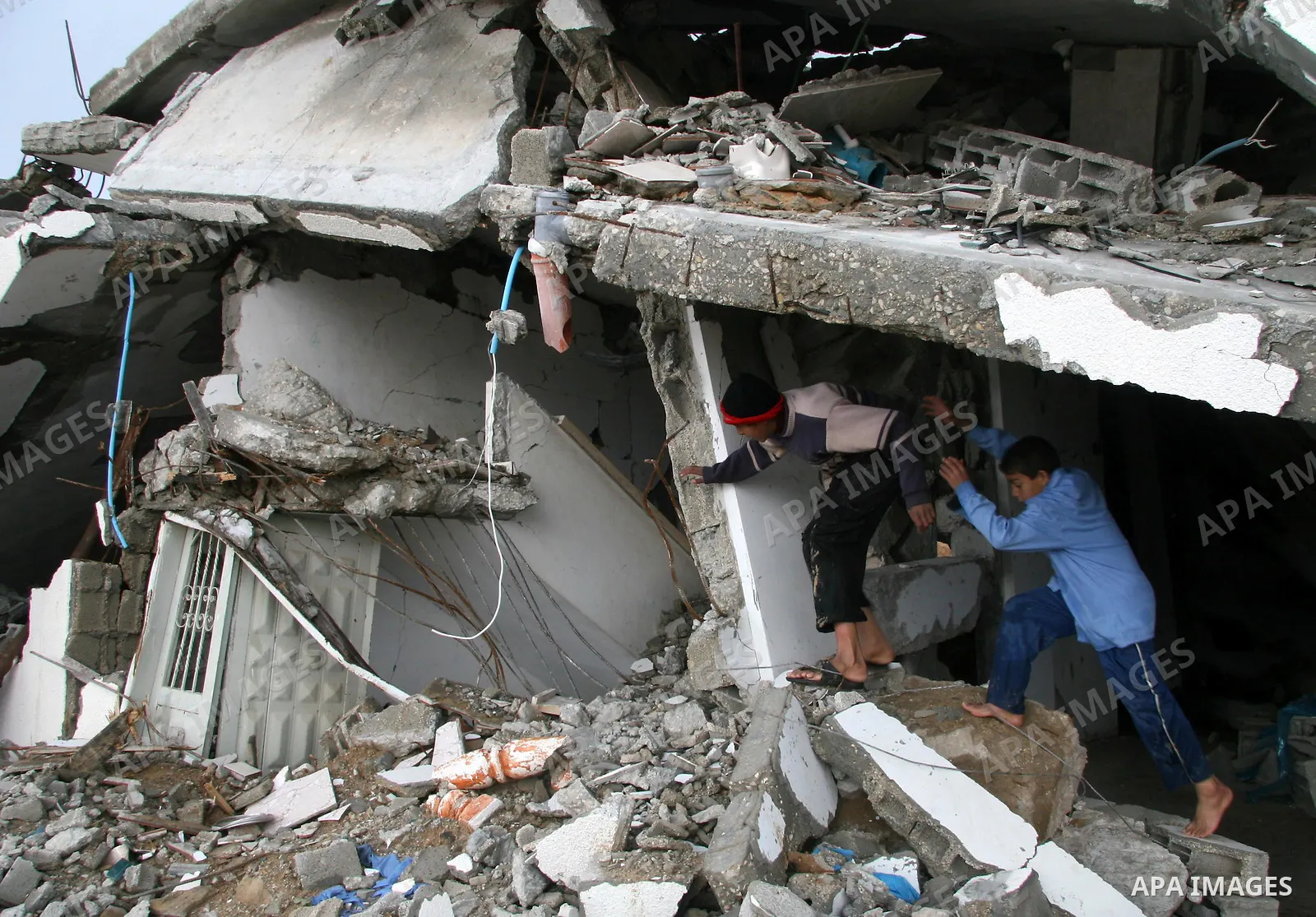 Palestinians walk past a house destroyed during Israel's 22-day offensive, in Jabalya in the northern Gaza Strip March 1, 2009. The World Bank said on Sunday it would urge international financial support for rebuilding t...