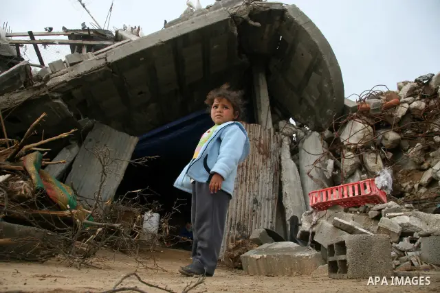 Palestinians walk past a house destroyed during Israel's 22-day offensive, in Jabalya in the northern Gaza Strip March 1, 2009. The World Bank said on Sunday it would urge international financial support for rebuilding t...