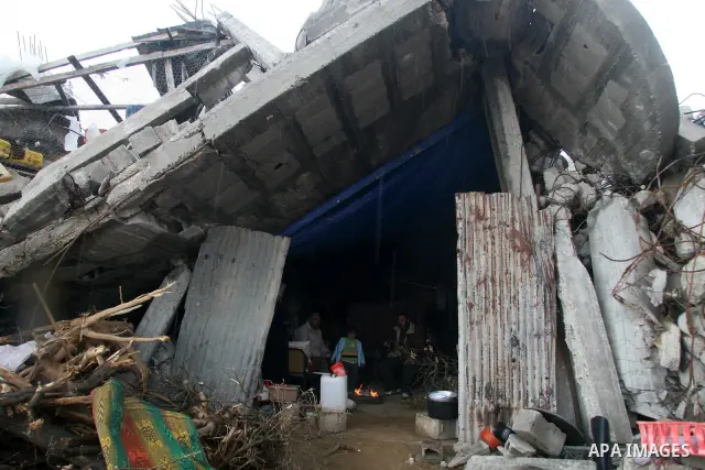 A Palestinian evacuates his belongings from a tent that housed people who had lost their homes during Israel's 22-day offensive, after heavy rain in east of Gaza March 1, 2009. The World Bank said on Sunday it would urge...