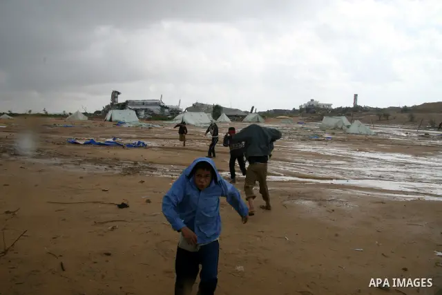 A Palestinian evacuates his belongings from a tent that housed people who had lost their homes during Israel's 22-day offensive, after heavy rain in east of Gaza March 1, 2009. The World Bank said on Sunday it would urge...