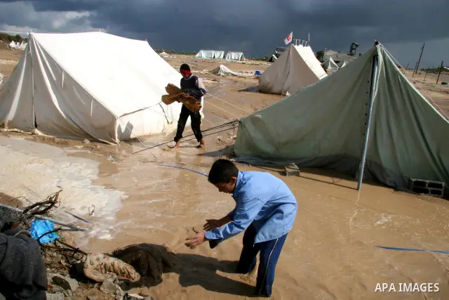 A Palestinian evacuates his belongings from a tent that housed people who had lost their homes during Israel's 22-day offensive, after heavy rain in east of Gaza March 1, 2009. The World Bank said on Sunday it would urge...