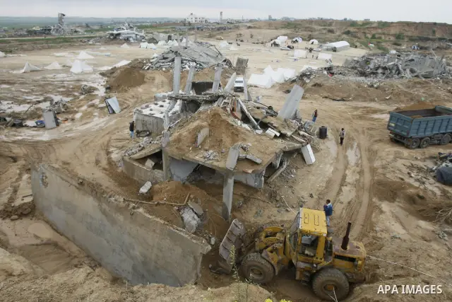 Palestinians use a bulldozer to remove debris of a house which was destroyed during Israel's 22-day offensive in Jabalia in the northern Gaza Strip on March 2, 2009. Donors meeting in Egypt are expected to pledge billion...