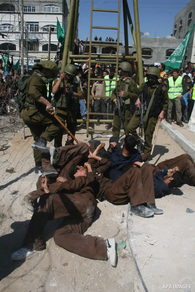 Palestinians enact a scene in which Israeli soldiers arrest Palestinians, during a protest organized by Hamas in Jabalya in the northern Gaza Strip April 17, 2009. In solidarity with Palestinian prisoners held in Israeli...