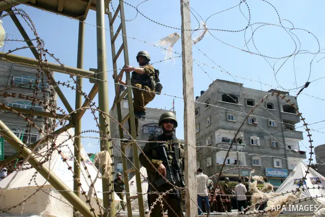 Hamas militantes stand nexta paint a mural depicting captured Israeli soldier Gilad Shalit during a rally demanding the release of Palestinian prisoners from Israeli jails in the Jablia refugee camp, northern Gaza Strip,...