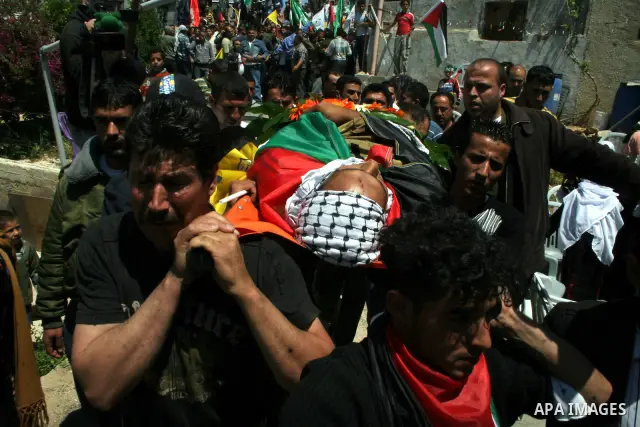 Palestinian mourners carry the body of Bassem Abu Rahmeh, 31, during his funeral procession in the West Bank village of Bilin, near Ramallah, Saturday, April 18, 2009. Abu Rahmeh was killed on Friday by Israeli troops at...