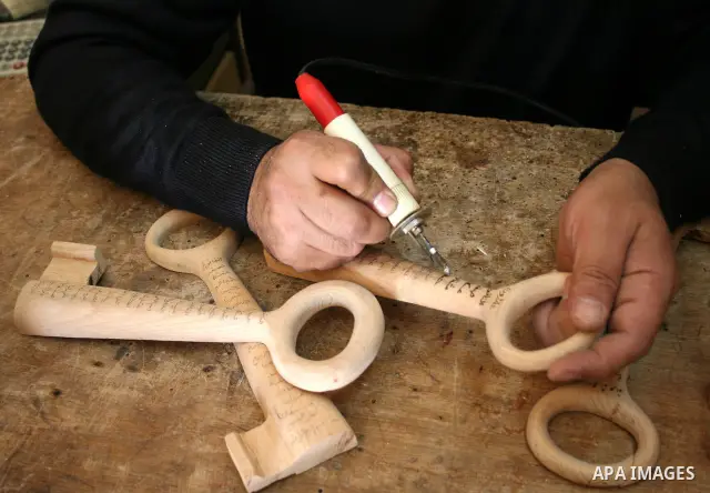 A Palestinian souvenirs maker makes a wooden key with the names of the villages and cities of the old Palestine at his shop in Gaza city, May 13, 2009. On Thursday, the Palestinians will mark their Nakba day, or the cata...