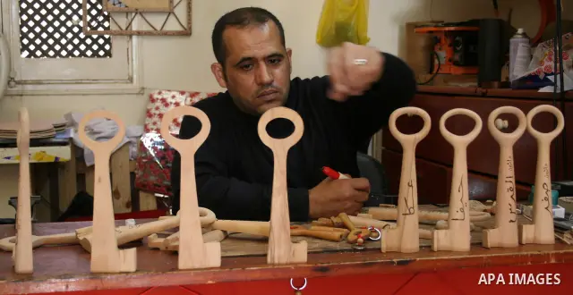 A Palestinian souvenirs maker makes a wooden key with the names of the villages and cities of the old Palestine at his shop in Gaza city, May 13, 2009. On Thursday, the Palestinians will mark their Nakba day, or the cata...