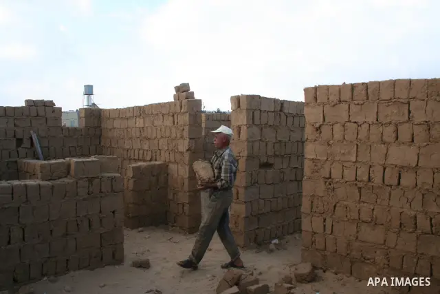 Palestinian workers use mud bricks to build a house in the southern Gaza Strip refugee camp of Rafah on May 24 2009. APAIMAGES PHOTO / Ashraf Amra
