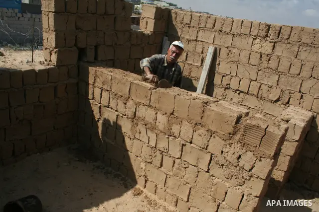 Palestinian workers use mud bricks to build a house in the southern Gaza Strip refugee camp of Rafah on May 24 2009. APAIMAGES PHOTO / Ashraf Amra