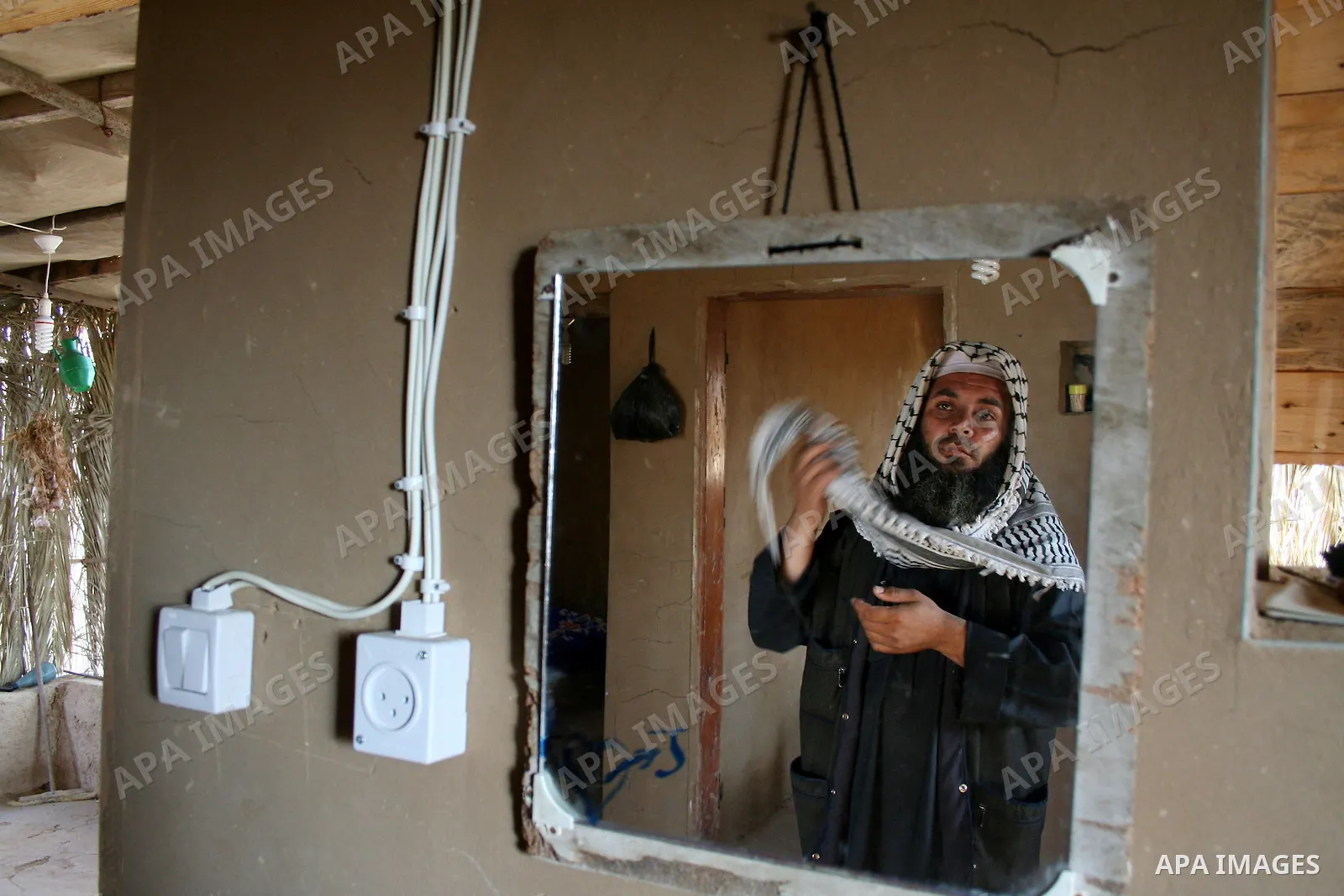 Palestinian Jihad al-Shaer, whose family home was destroyed during the last Israeli war on Gaza, stand in his new mud house in the southern Gaza Strip refugee camp of Rafah on May 24, 2009. the new mud house of jihad al-...