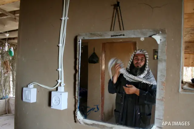 Palestinian Jihad al-Shaer, whose family home was destroyed during the last Israeli war on Gaza, stand in his new mud house in the southern Gaza Strip refugee camp of Rafah on May 24, 2009. the new mud house of jihad al-...