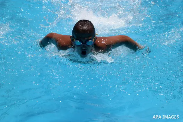 Palestinian boys jump into a swimming pool to cool off during a heat wave, in the West Bank city of Hebron on June 02, 2009. Photo \ Najeh Hashlamoun