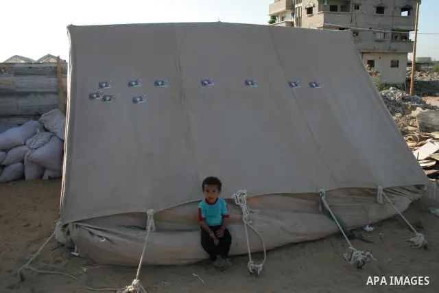 Palestinian girl stands in a makeshift hut after her family's house was destroyed during Israel's offensive in the Gaza Strip earlier this year, in al-Zaitoun neighbourhood of Gaza City on June 2, 2009. Twenty-nine membe...