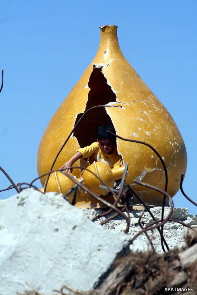 A Palestinian child plays in the rubble of a mosque as UN lead investigator Richard Goldstone and members of his delegation arrive closeby to inspect the destruction at the Samuni family home in Gaza City on June 03, 200...