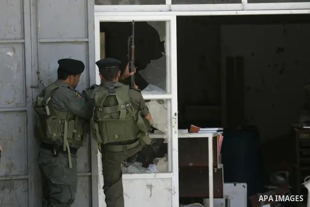 Palestinian security officers take position during a raid against Hamas gunmen in the West Bank town of Qalqiliya, Thursday, June 4, 2009. Three Hamas fugitives in Qalqiliya have opened fire on Palestinian police, killin...