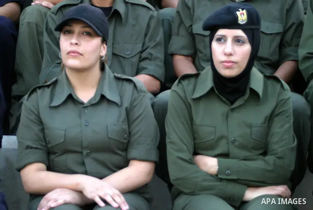 Palestinian security students watch a special police unit performing in their graduation ceremony in the West Bank city of Jericho on June 15, 2009. Photo\Najeh Hashlamoun