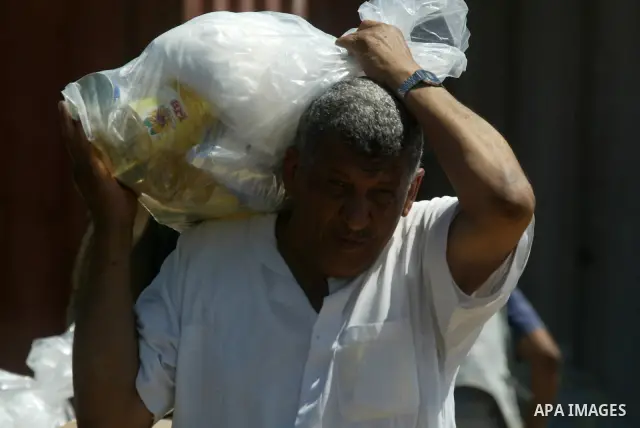 A Palestinians receive monthly food aid from the United Nations Relief and Works Agency (UNRWA) center in the Rafah refugee camp, southern Gaza on June 17, 2009. UNRWA has provided food, housing, education and health car...