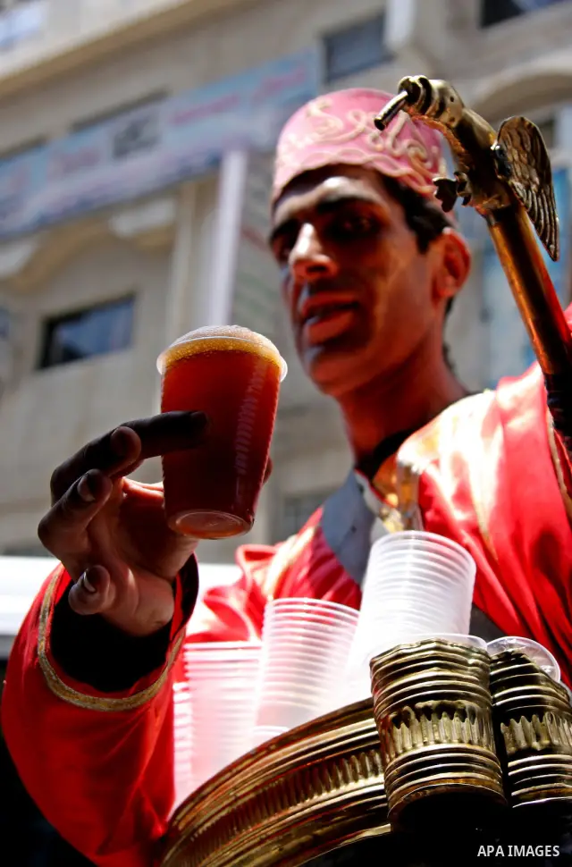 A Palestinian vendor sells El-Kharoub drink in the centre of the West Bank city of Ramallah on June 21, 2009. El_Kharoub is sweet black plant, is soaking in a water to make a sweet drink and selling in the Summer season....