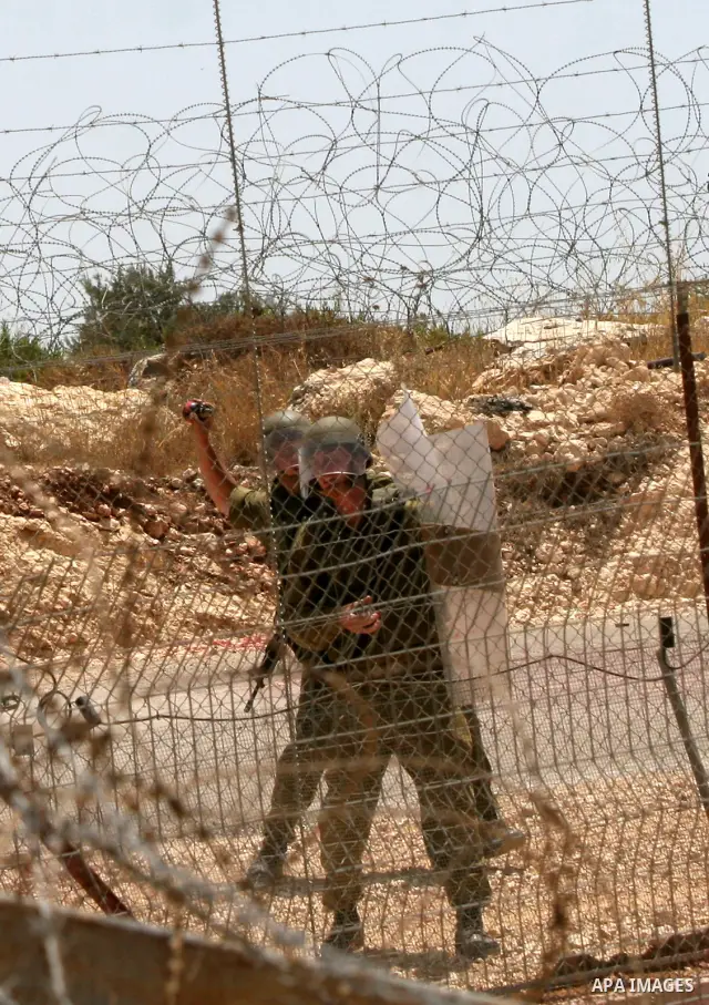A Palestinian protesters clash with Israeli soldiers during a demonstration against Israel's controversial separation barrier in the West Bank village of Bilin near Ramallah on June 26, 2009. Photo by Nedal Shtieh