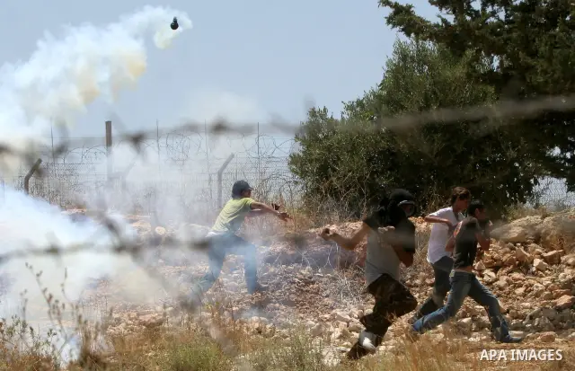 A Palestinian protesters clash with Israeli soldiers during a demonstration against Israel's controversial separation barrier in the West Bank village of Bilin near Ramallah on June 26, 2009. Photo by Nedal Shtieh