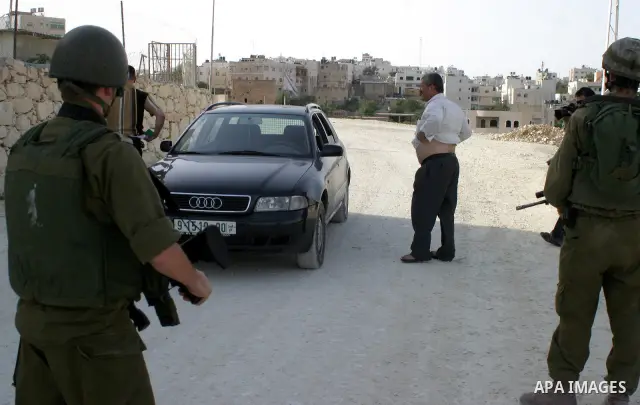 Israeli soldiers search palestinians during a military operation in the West Bank city Hebron on July1, 2009. Photo by Najeh Hashlamoun